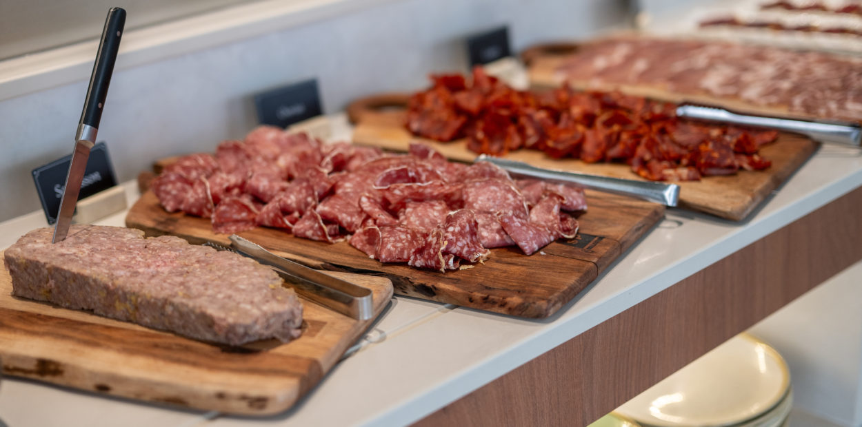 Buffet de brunch gourmand avec charcuterie et brochettes de viande grillée servis sur des planches en bois